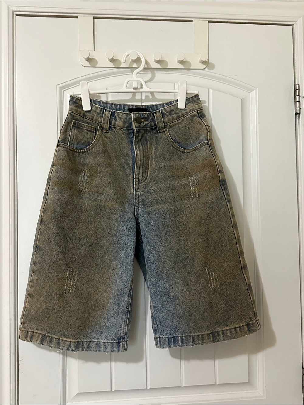 Oversized denim shorts with faded wash and distressed details